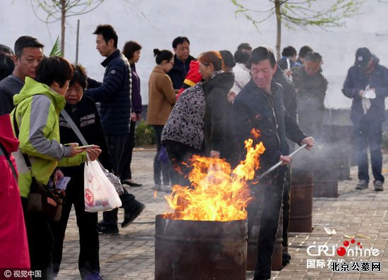 2016年04月02日，北京通惠陵园，市民在专用安全焚烧点为已故亲人烧纸。图片来源:李文明/视觉中国