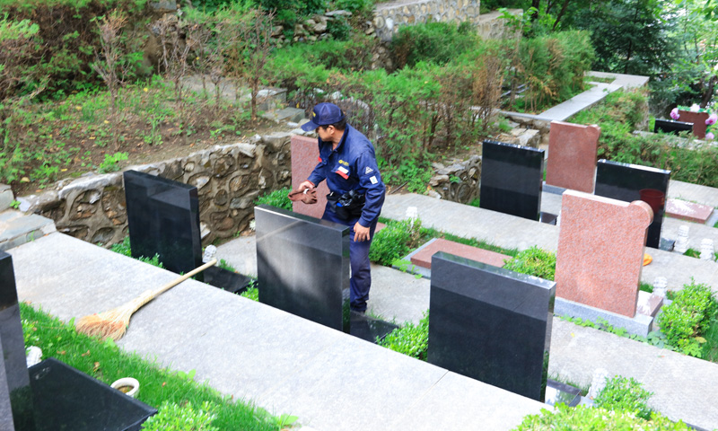 九公山长城纪念林墓园保洁正在打理墓碑