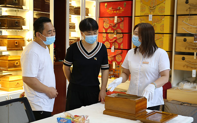 天顺祥店员向家属介绍金丝楠木骨灰盒特点及注意事项